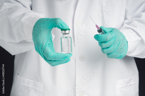 A doctor or scientist in a laboratory holding a syringe with a vaccine bottle for research and development of vaccines. Concept of medical and the fight against the virus