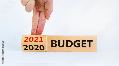 Business concept of budget planning 2021. Businessman flips wooden cube and change words 'BUDGET 2020' to 'BUDGET 2021'. Beautiful white background, copy space. Budget 2021 new year symbol.