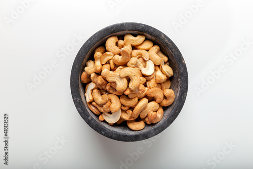 Cashew fruit in black marble pestle on white background. Top view.