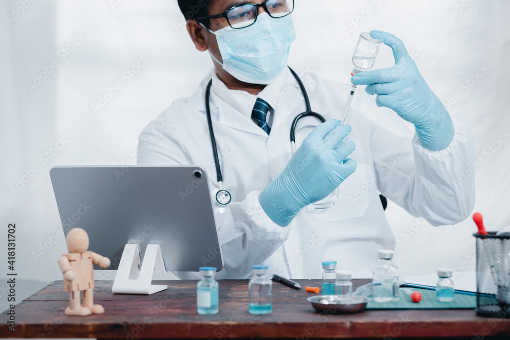 Doctors or scientists are experimenting with the science of a vaccine to treat COVID-19 with a laptop, work in a lab or hospital. The concept of doing it with new and normal technology. Doctors or scientists are experimenting with the science of a vaccine to treat COVID-19 with a laptop, work in a lab or hospital. The concept of doing it with new and normal technology.