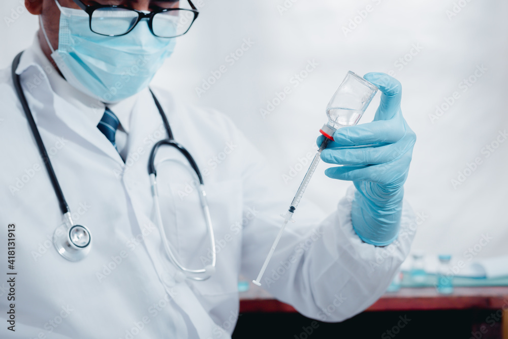 A doctor or laboratory scientist holds a syringe with a vaccine against the COVID 19 for new patients. Concept of protection against new virus strains
A doctor or laboratory scientist holds a syringe with a vaccine against the COVID 19 for new patients. Concept of protection against new virus strains