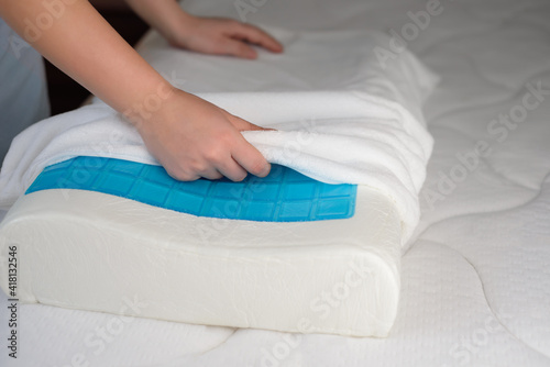 Women's hands put a cover on the orthopedic pillow with cooling gel. Protecting the foam pillow from moisture