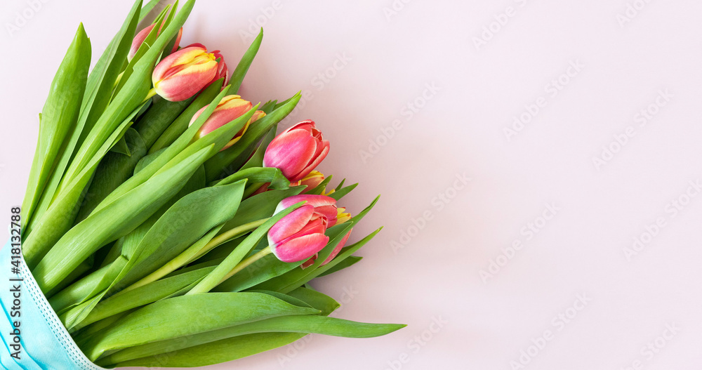 Spring flowers. Banner-a bouquet of pink and yelloy tulips in the mask on a pink background. Congratulations on International Women's Day, March 8, birthday, mother's Day. Copy space. Mock up. Spring flowers. Banner-a bouquet of pink and yelloy tulips in the mask on a pink background. Congratulations on International Women's Day, March 8, birthday, mother's Day. Copy space. Mock up.