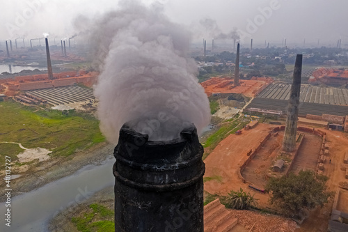 Aerial view of chimneys kilns from brick factory surrounding the area along Dhaleshwari river near Keraniganj township, Dhaka, Bangladesh. photo