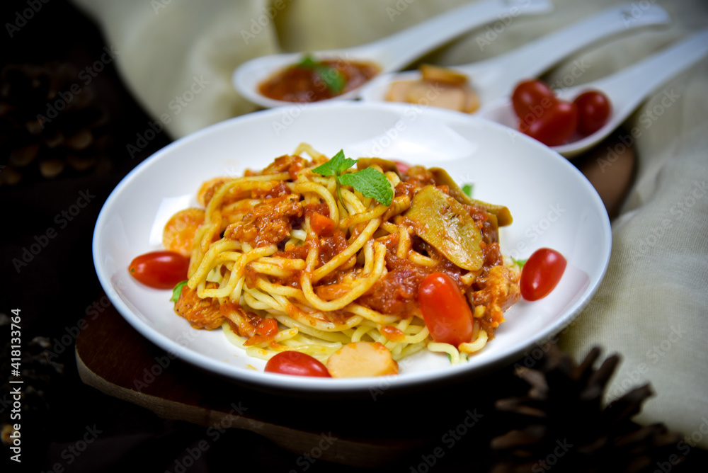 Delicious classic Italian spaghetti with tomato sauce, Parmesan cheese and mint leaves on a plate. There is a writing area.