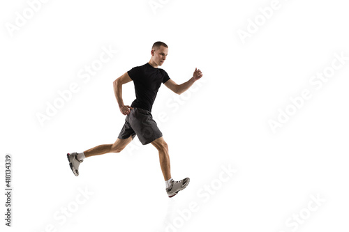 Running. Young caucasian male model in action, motion isolated on white background with copyspace. Concept of sport, movement, energy and dynamic, healthy lifestyle. Training, practicing. Authentic.