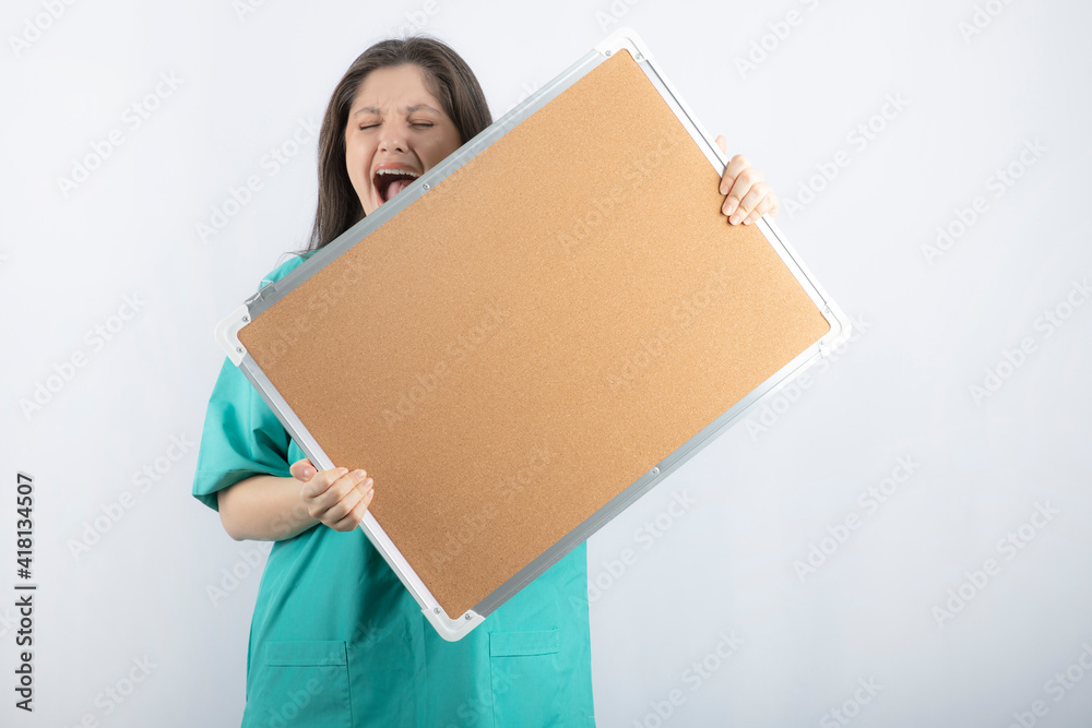 Screaming young medical worker holding a board with hands Screaming young medical worker holding a board with hands