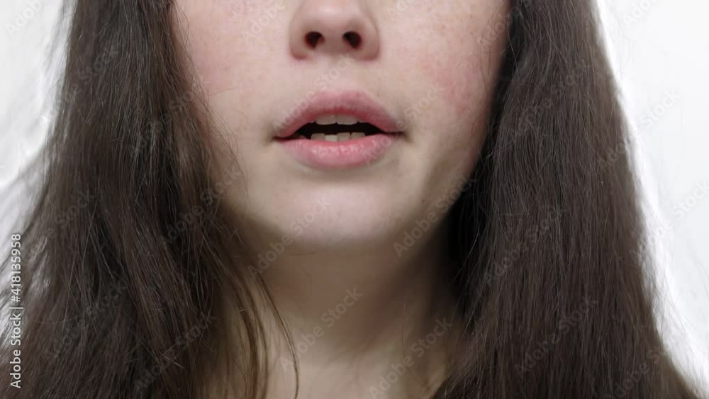 Drowsiness and fatigue. A young, sleepy woman yawns. Close-up view. White background. Soft focus. Drowsiness and fatigue. A young, sleepy woman yawns. Close-up view. White background. Soft focus.