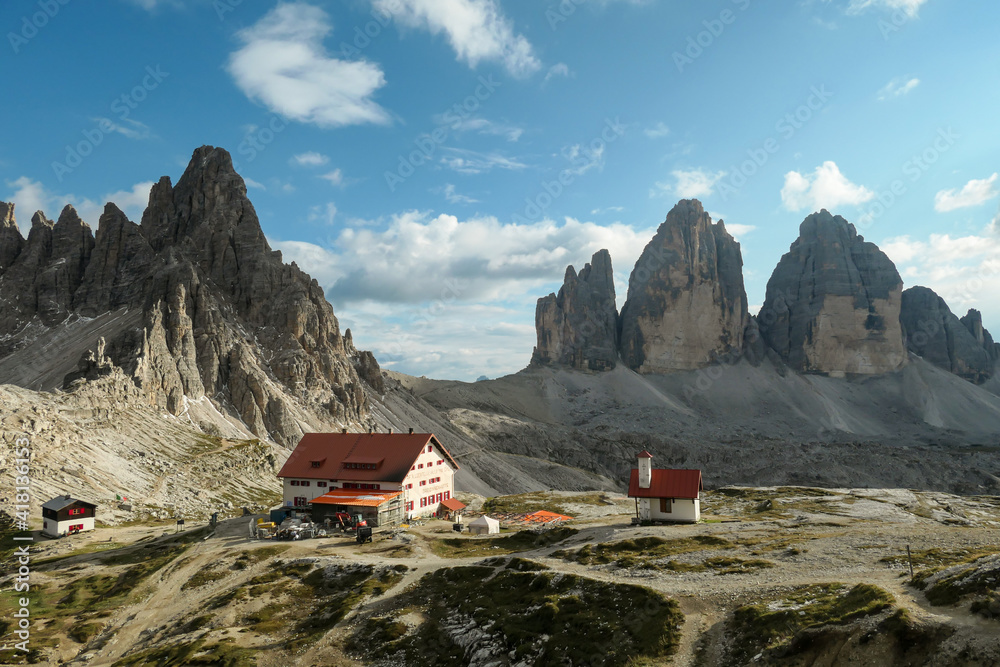 Drei Zinnenhuette and a small chapel, with red rooftop and small bell tower with the view on the Tre Cime (Drei Zinnen) in Italian Dolomites. There are high Alpine peaks around. Sunny day. Shelter
