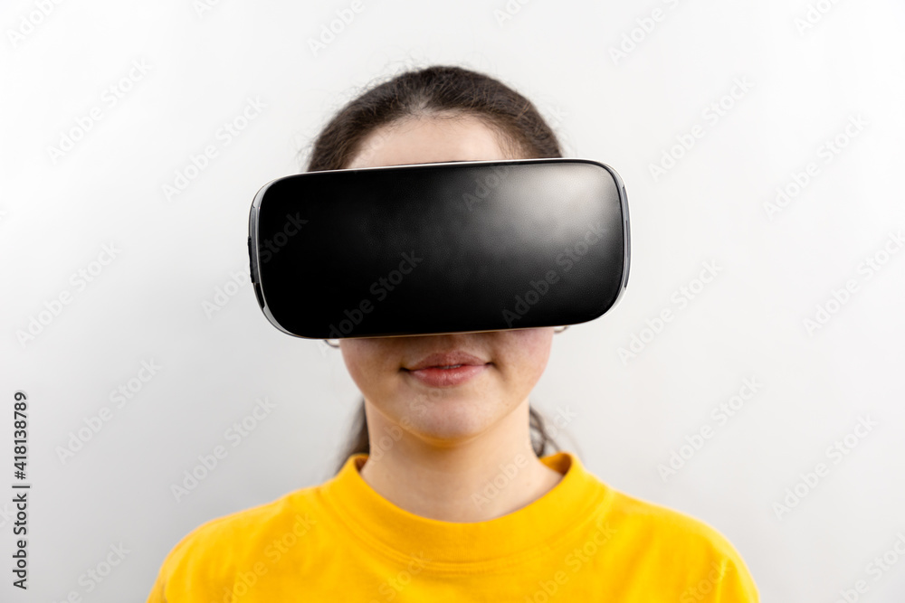 Full-face close-up portrait of a young woman wearing virtual reality glasses. White background. The concept of virtual reality and modern technologies