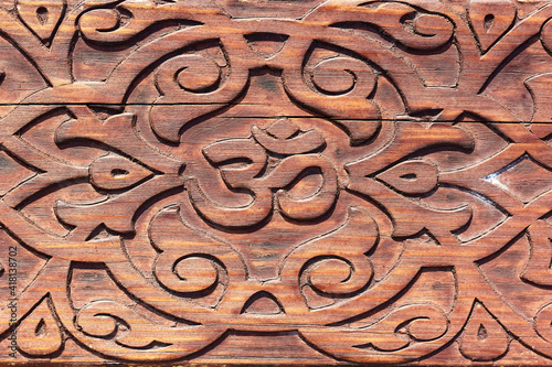 OM sign carved with a pattern on a wooden bench