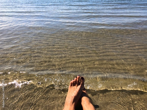 Woman's feet at water's edge by the sea, Fanoe, Jutland, Denmark photo