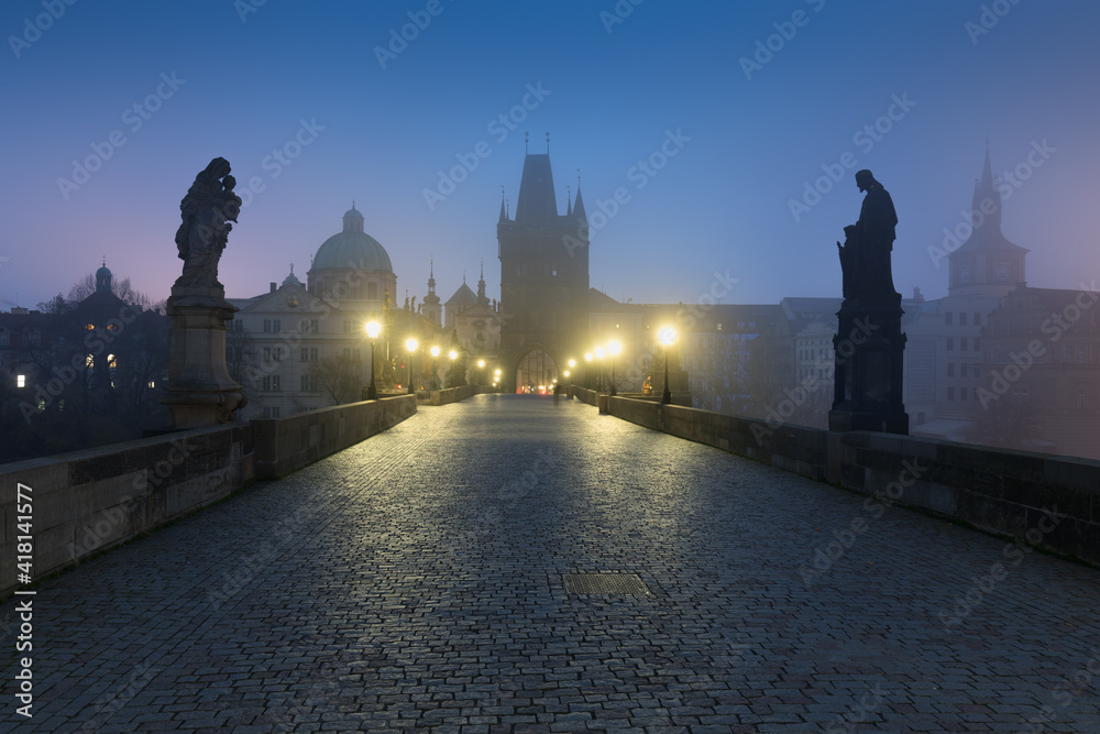 Obraz premium Empty Charles bridge, Prague during sunrise at a time of coronavirus lockdown, Czechia. No tourists,no guards. Famous travel destination during COVID-19 pandemic lockdown.
