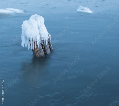 Ice breakwaters, covered with snow, stand in the winter sea. sea winter landscape background.