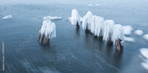 Ice breakwaters, covered with snow, stand in the winter sea. sea winter landscape background. © Alexandra Mareeva