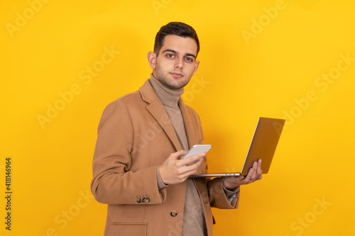 young man with smartphone and laptop isolated on background