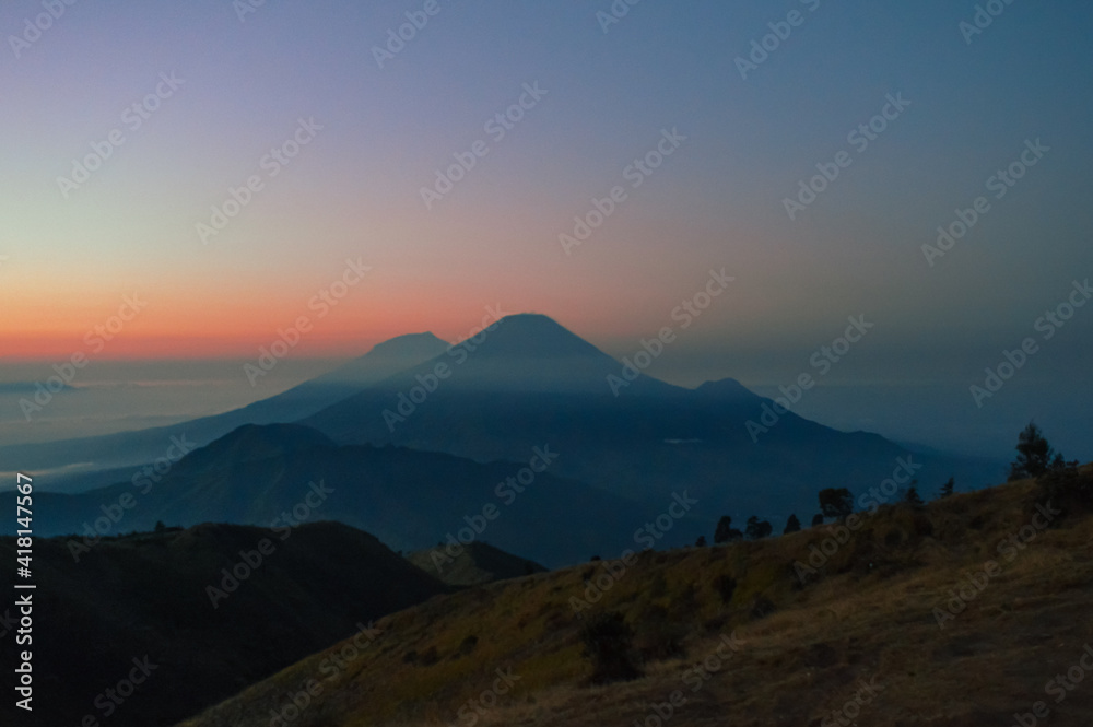 a photo of beautiful sunrise in the mountain in Indonesia. Panoramic view of colorful sunrise in mountains. Filtered image:cross processed vintage effect. 