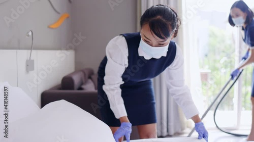 Maid cleaning woman Provide housekeeping service in bedroom of hotel and residence. Maintain cleanliness by professional cleaning staff. Concept Cleaning business 
