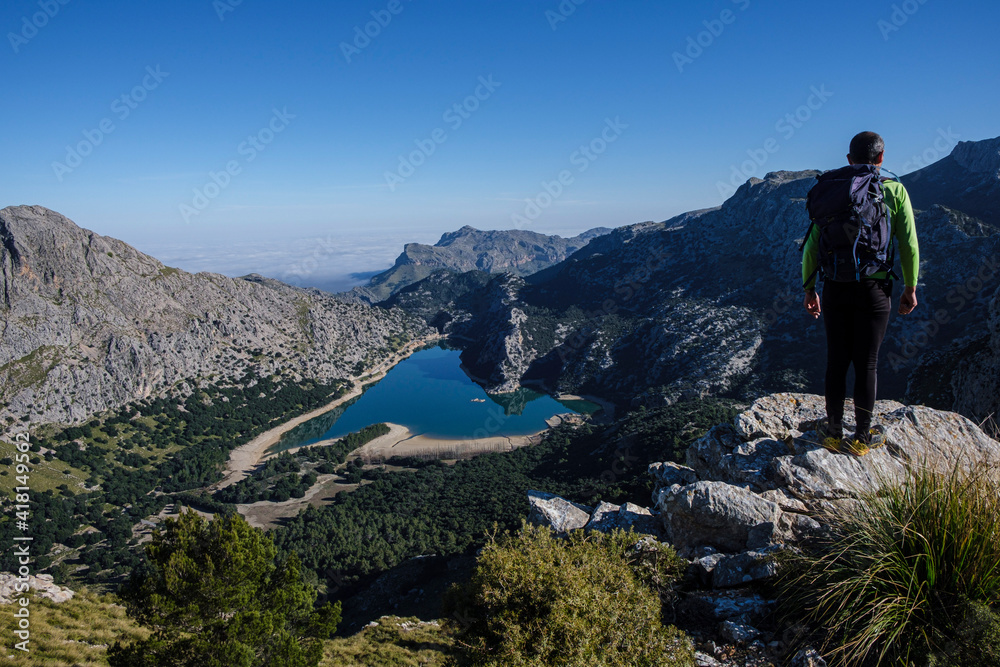 Naklejka premium hiker watching Gorg Blau reservoir, Escorca, Mallorca, Balearic Islands, Spain