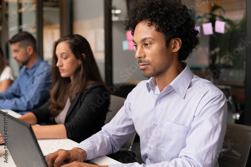 african american man working and typing in laptop in workstation. .