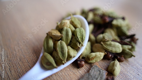 Green cardamom pods on rustic wooden background. Indian spices macro view. elaichi (Elettaria cardamomum)