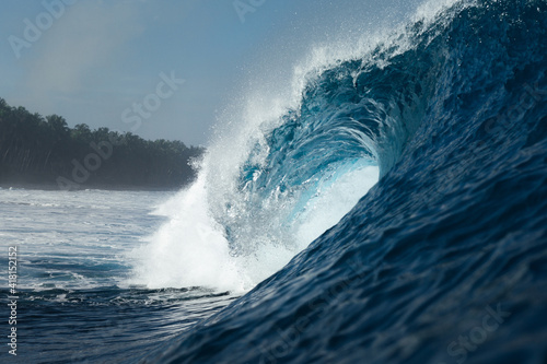 Blue wave breaking on a beach in sea photo