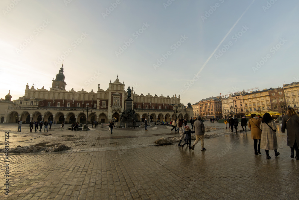 Krakow, Poland: Panorama of Cloth Hall (Sukiennice) - located on Main Square (Plac Mariacki) and serving as the handicraft market and people walking in the city center