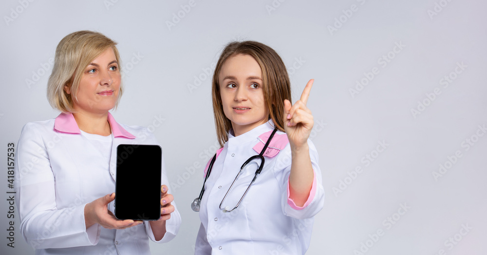 Banner- long format. Forefinger up. Doctors using digital tablet computer mock up black screen, consulting patient online. Video calling on gray. Telemedicine video call consultation concept. . Banner- long format. Forefinger up. Doctors using digital tablet computer mock up black screen, consulting patient online. Video calling on gray. Telemedicine video call consultation concept. .