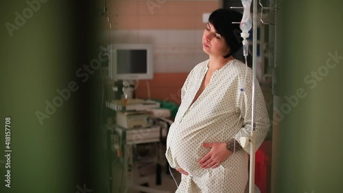 A pregnant woman holds her belly with her hands in contractions. Stimulation of labor. Relaxation of muscle tone. Preparing for childbirth. photo