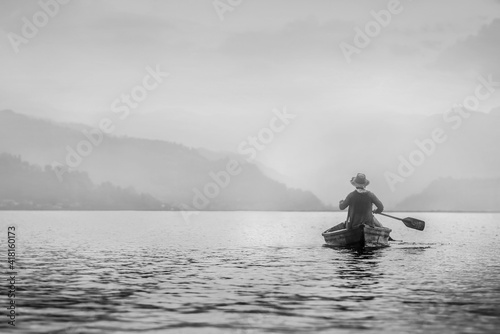 Man on aboat fishingi in black and white