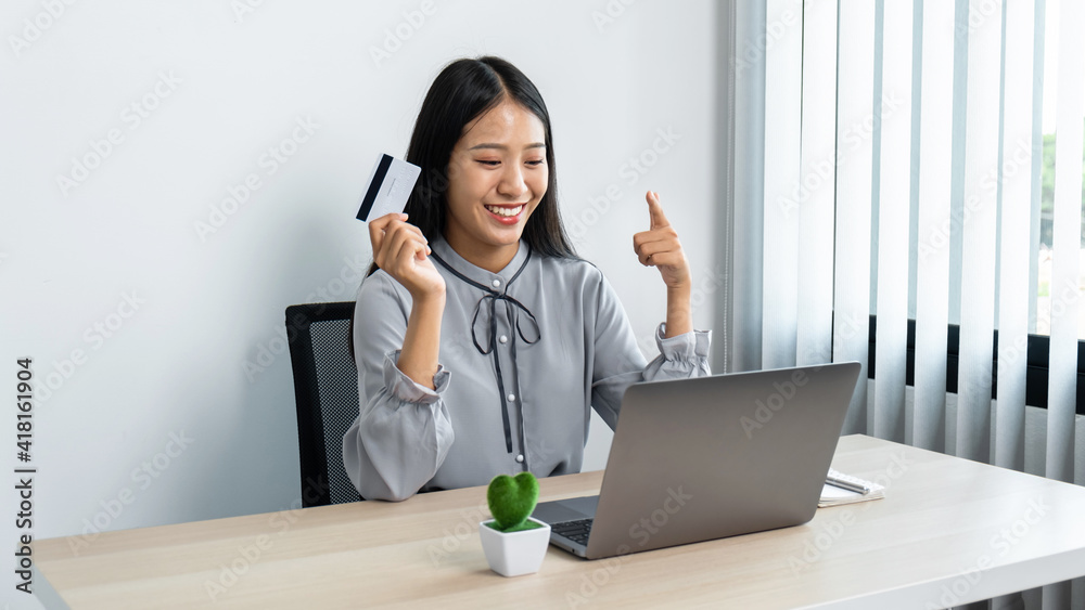 Young asian woman using laptop for online shopping and holding credit card Young asian woman using laptop for online shopping and holding credit card