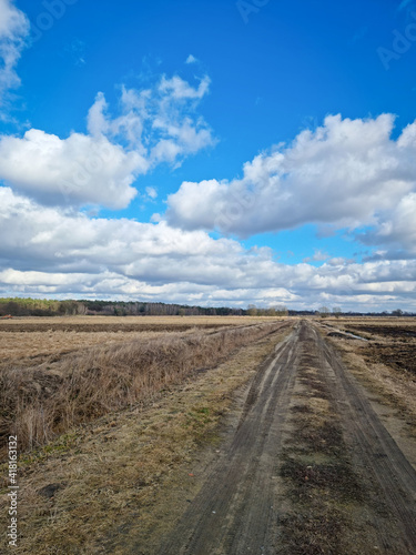 DROGA POLNA PRZEZ ŁĄKI. WCZESNA WIOSNA NA POLACH UPRAW. ROZTOPY WIOSENNE. © michalsen