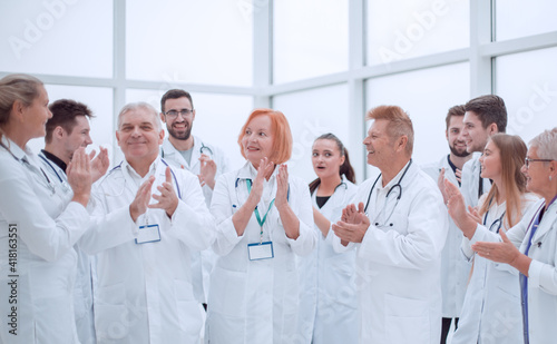 group of diverse smiling doctors applauding together.
