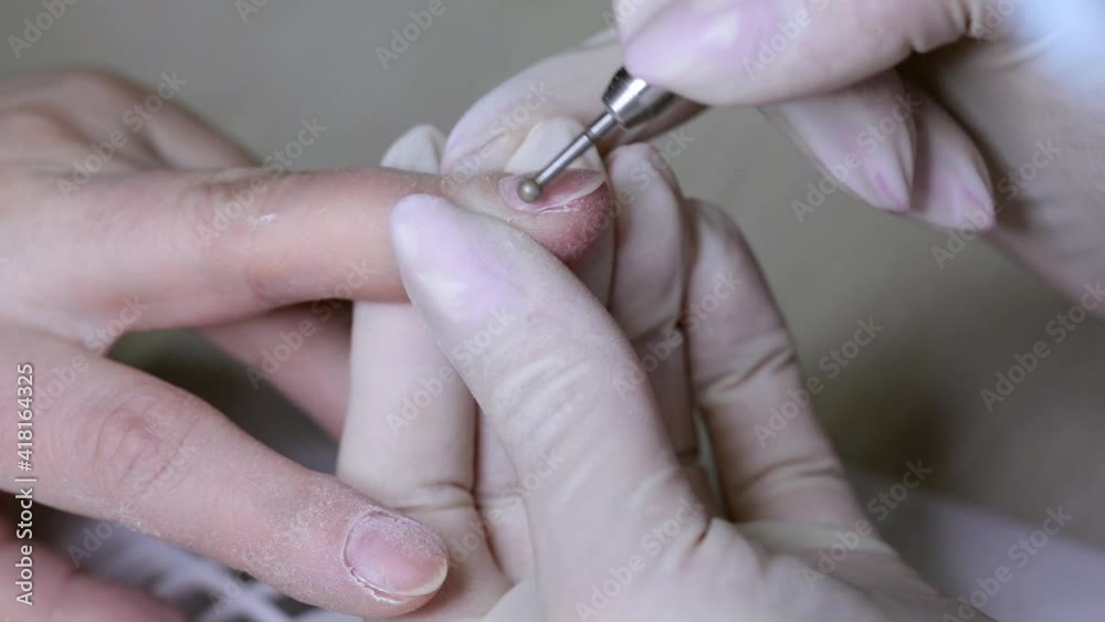 Processing of rough cuticles and lateral folds of fingernails with a round instrument. Medical hardware manicure in a beauty salon. Processing of rough cuticles and lateral folds of fingernails with a round instrument. Medical hardware manicure in a beauty salon.