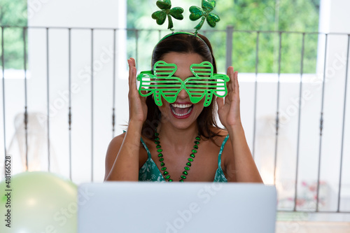 Caucasian woman celebrating st patrick's day making video call wearing deely boppers and glasses photo