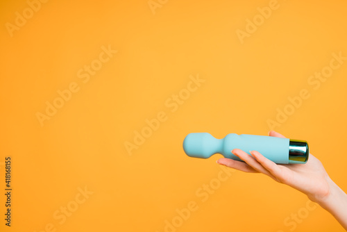 Blue vibrator or masturbation massager on an orange background. Flat Lay. Sex shop concept photo