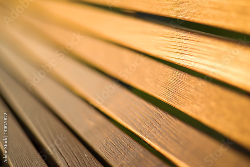 Backrest of a wooden bench in the park close-up. The texture of the wood is visible.