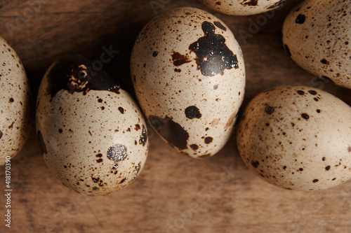 top view on quail eggs close up on wooden table. macro photo of raw quail eggs 