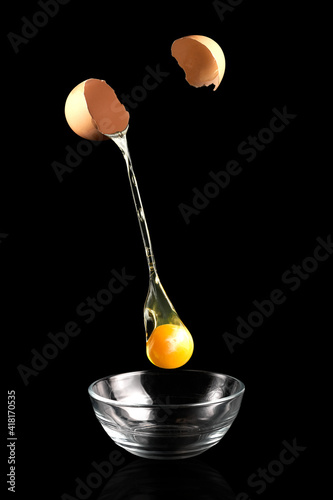 Bild auf Leinwand Egg yolk dripping, falling on black background
