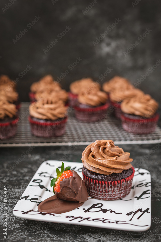 Chocolate Cupcake on Bon Appetit Plate with a ChocolateCovered Strawberry Against a Black