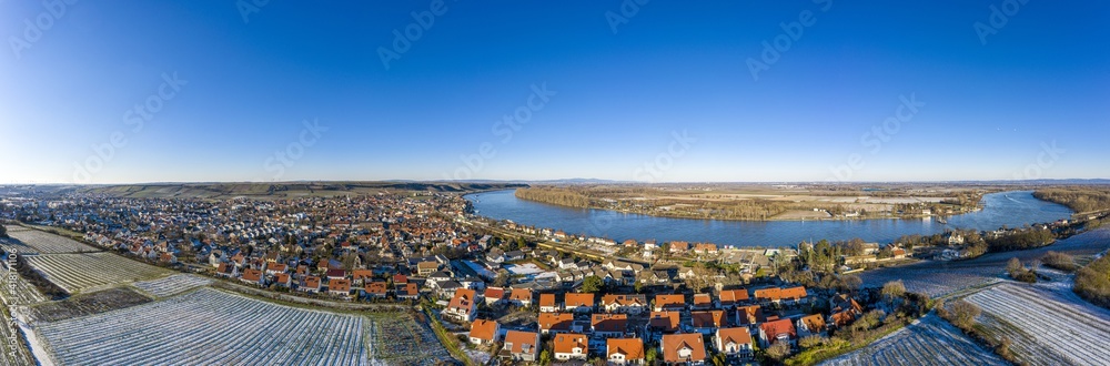 Drone image of wine village Nierstein on the Rhine in blue sky and sunshine with snow covered slopes