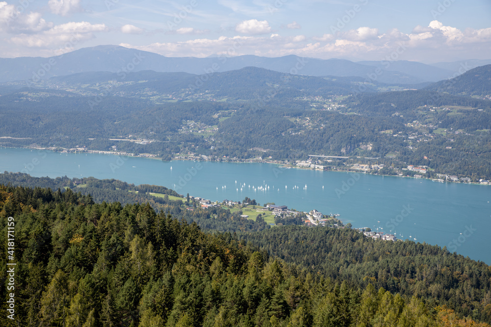 Panoramic top view of the green Austrian Alps, villages and Werthersee lake