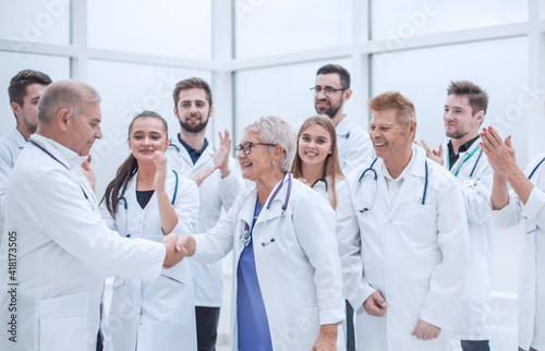 happy medical colleagues shaking hands with each other.