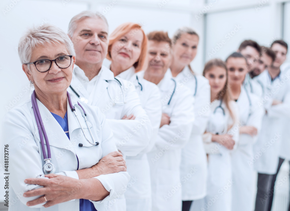 senior female doctor standing in front of her colleagues. senior female doctor standing in front of her colleagues.