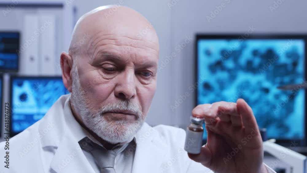 Elderly professor is doing a science experiment in a modern laboratory. Genetic engineers workplace. The concept of science, medicine and vaccine development. Elderly professor is doing a science experiment in a modern laboratory. Genetic engineers workplace. The concept of science, medicine and vaccine development.
