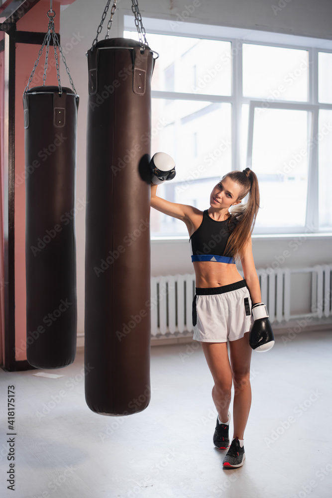 Beautiful Kickboxing woman tired from training in fitness studio