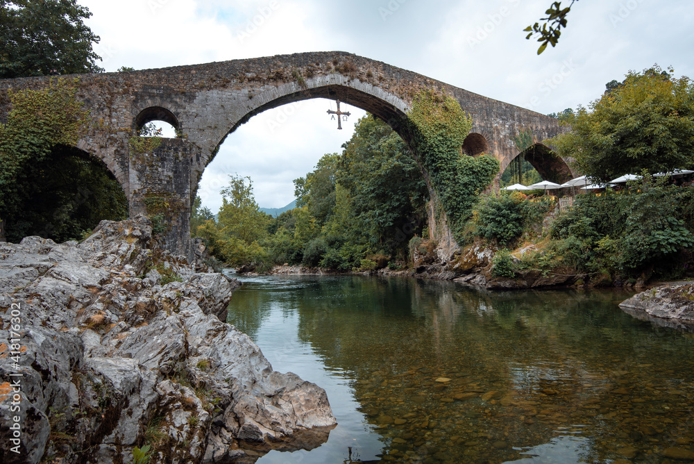 beautiful Roman bridge located in Cangas de Onis, Asturias next to the Sella river on a summer day.