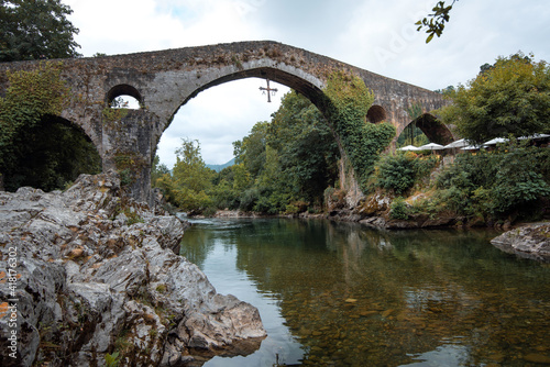 beautiful Roman bridge located in Cangas de Onis, Asturias next to the Sella river on a summer day.