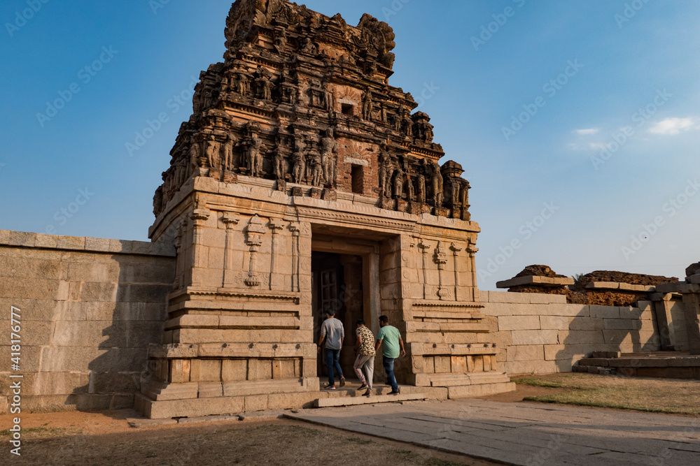 Tourists at a ruined temple in Hampi, Karnataka, India.  Ruins of the ancient city at sunset.  Remains of an ancient empire.