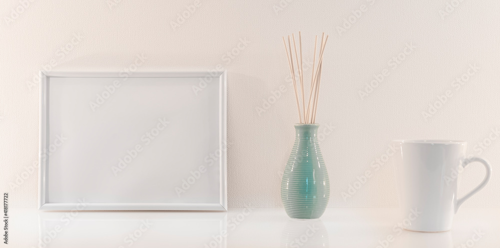 Modèle de cadre photo blanc avec espace vide pour logos, inscription publicitaire. Cadre en mode paysage sur un espace de travail avec une tasse. Ambiance zen. Modèle de cadre photo blanc avec espace vide pour logos, inscription publicitaire. Cadre en mode paysage sur un espace de travail avec une tasse. Ambiance zen.
